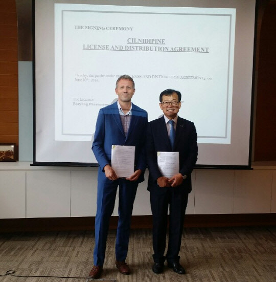 지난달 26일 싱가포르 산도즈아시아태평양 지사에서 진행된 실니디핀정 수출 계약식에서 최태홍 보령제약 대표(오른쪽), 폴 게이마이어 산도즈 아시아 총괄 대표가 계약서 서명 후 기념사진을 찍고 있다.(사진 보령제약 제공)